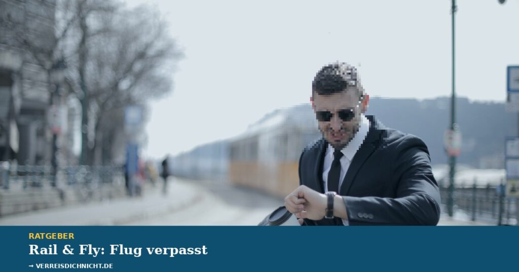 Rail and Fly Flug verpasst – Reisender im Anzug blickt besorgt auf die Uhr, Zug im Hintergrund