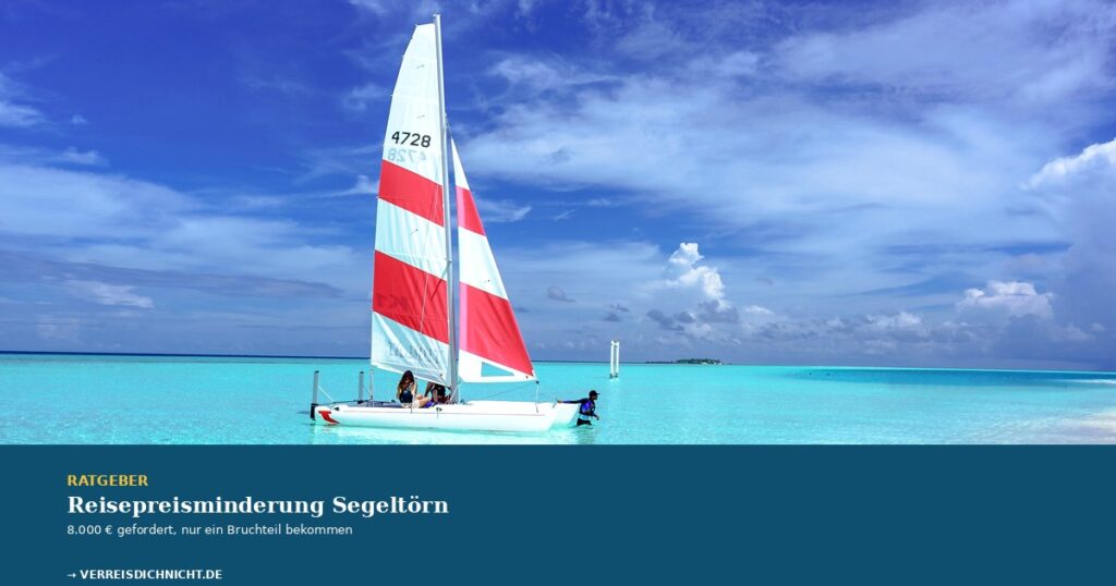 Reisepreisminderung Segeltörn – Katamaran mit rot-weißem Segel in türkisfarbener Karibik-Lagune