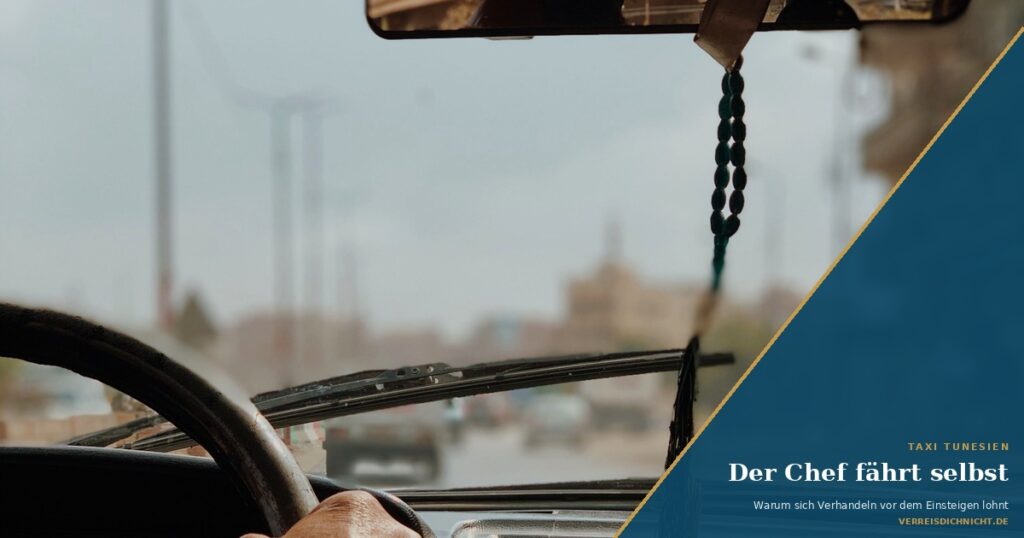 Hand am Lenkrad eines Taxis in Tunesien, Gebetskette am Rückspiegel, Symbolbild zum Beitrag Taxi Tunesien